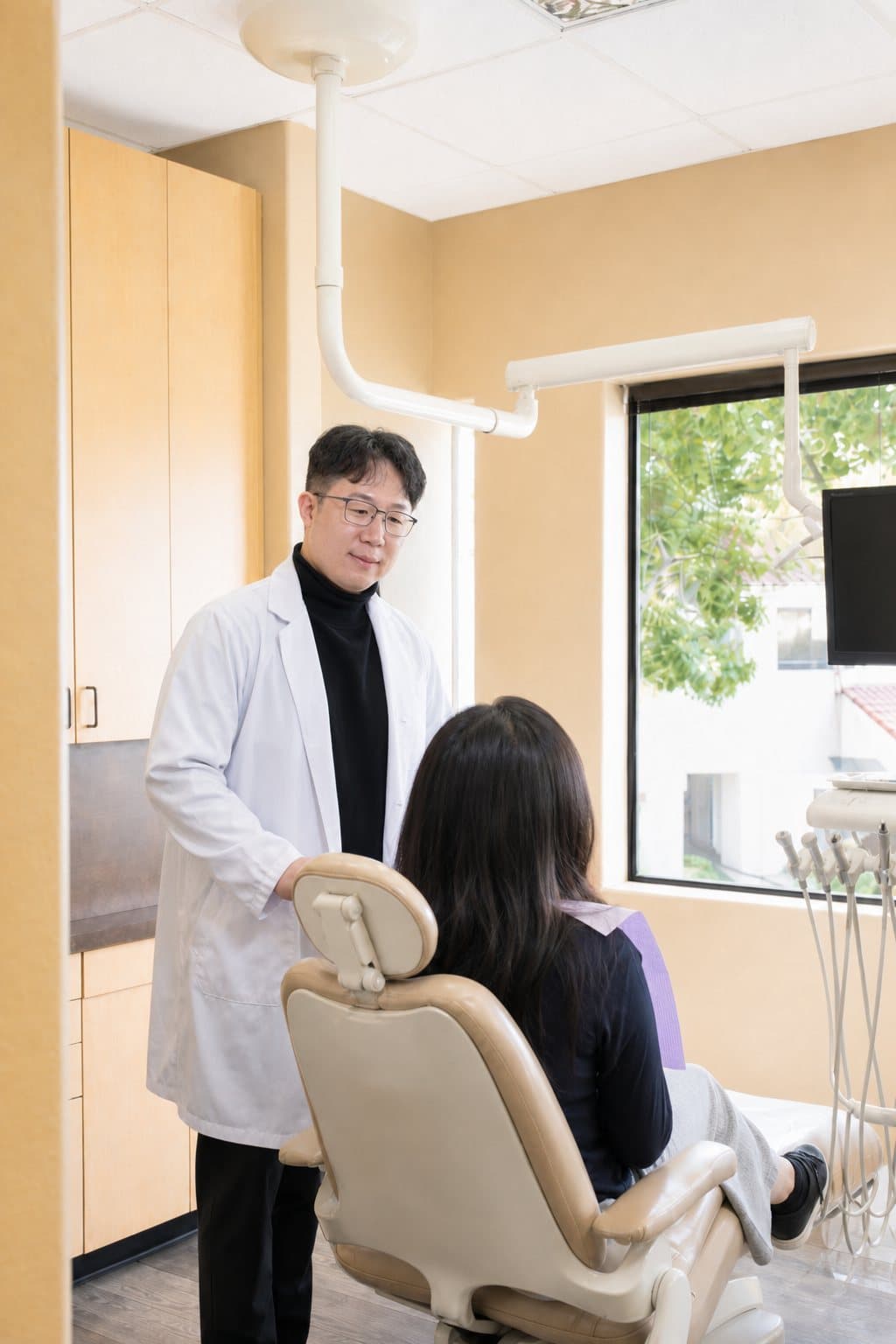 Dr. Jeong with a patient during an exam in a treatment room at Gilead Dental